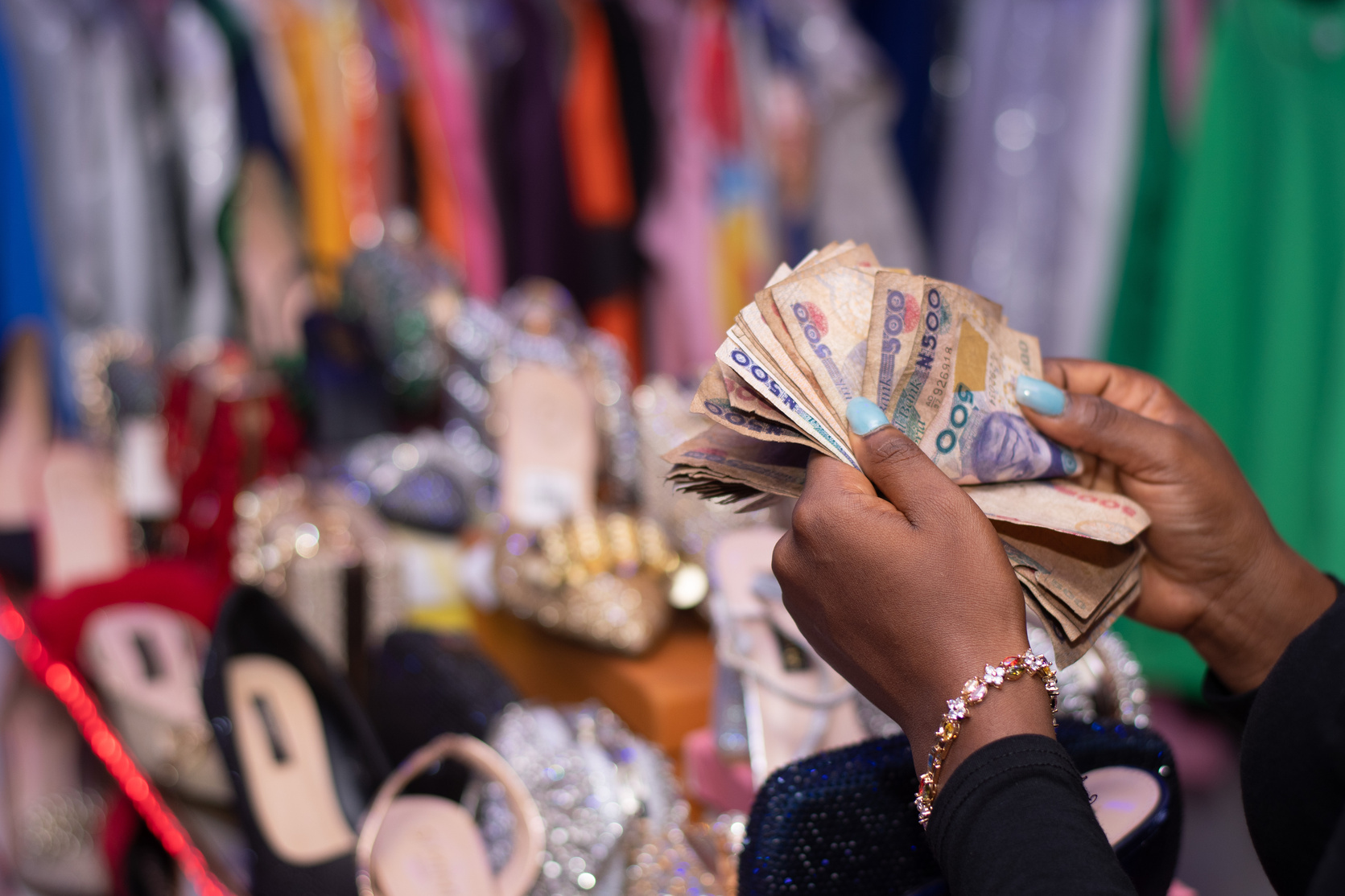 African Person Counting Money in a Shop